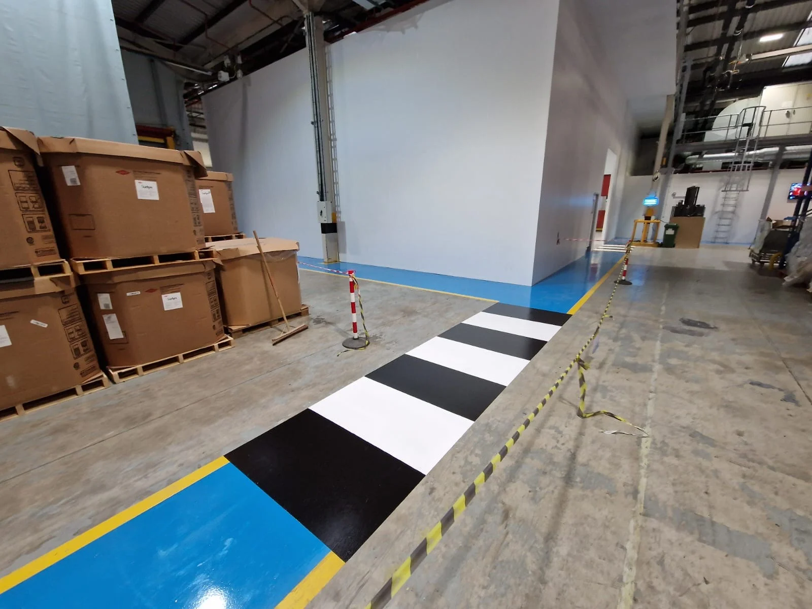 An image of demarcation and line markings on a resin floor in an industrial setting.